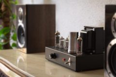 Audio tube amplifier with speakers on a coffee table.
